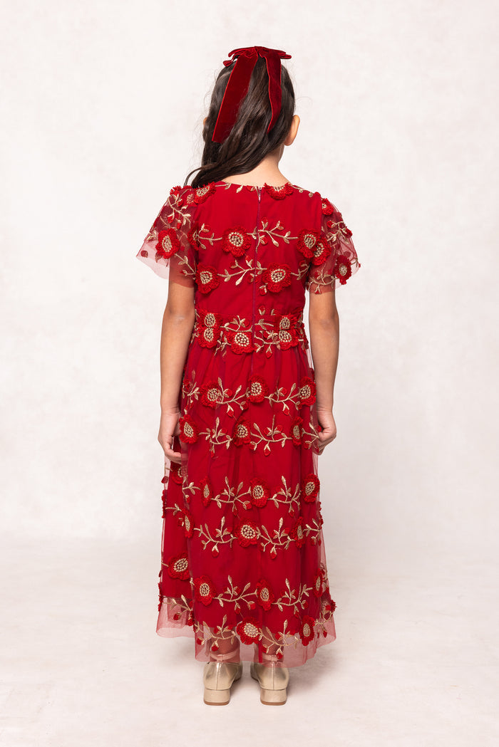 Red embroidered dress worn by a person on a white background