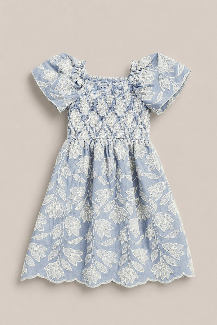 The Mini Ophelia Dress in Mosaic Embroidery by Ivy City Co features a light blue hue, white mosaic embroidery, puffed sleeves, smocked bodice, and scalloped hems. Shown laid flat on a neutral background. Perfect for Mom and Me matching looks.