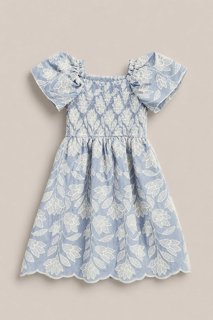 The Mini Ophelia Dress in Mosaic Embroidery by Ivy City Co is a light blue toddler dress featuring a smocked bodice, puff sleeves, and delicate white mosaic embroidery throughout. Scalloped edges on the skirt and sleeves add an elegant touch, making it a charming choice for Mom and Me matching moments.