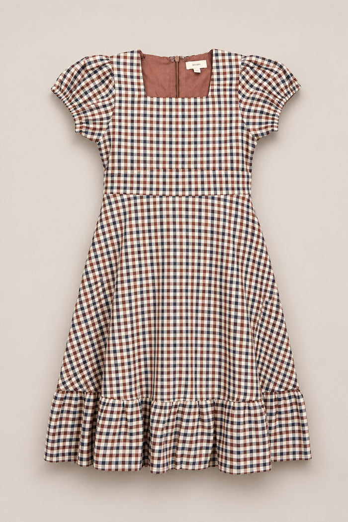 The Ivy City Co Teen Connie Short Sleeve Dress in Chestnut Gingham, featuring a brown, white, and blue checkered pattern, puff sleeves, a square neckline, fitted waist, flared knee-length skirt with ruffled hem, and gathered short sleeves, is displayed flat against a neutral background.
